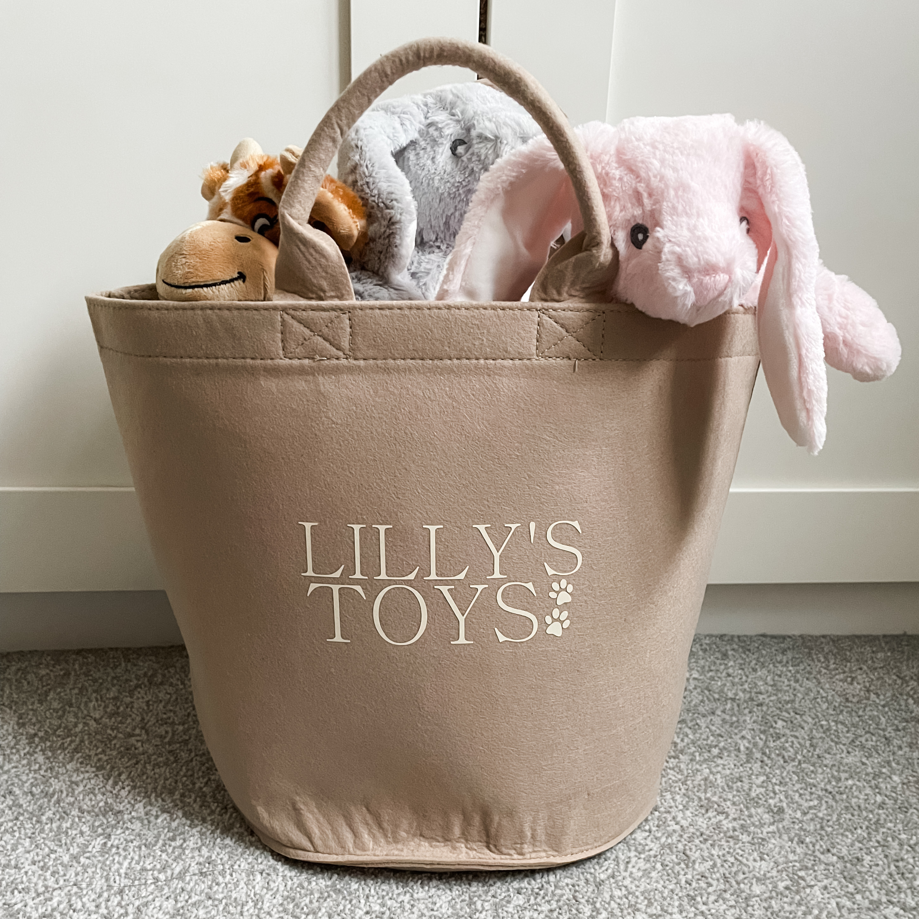 Personalised sand coloured dog toy basket with cream custom text. Durable pet storage bin with carry handles.