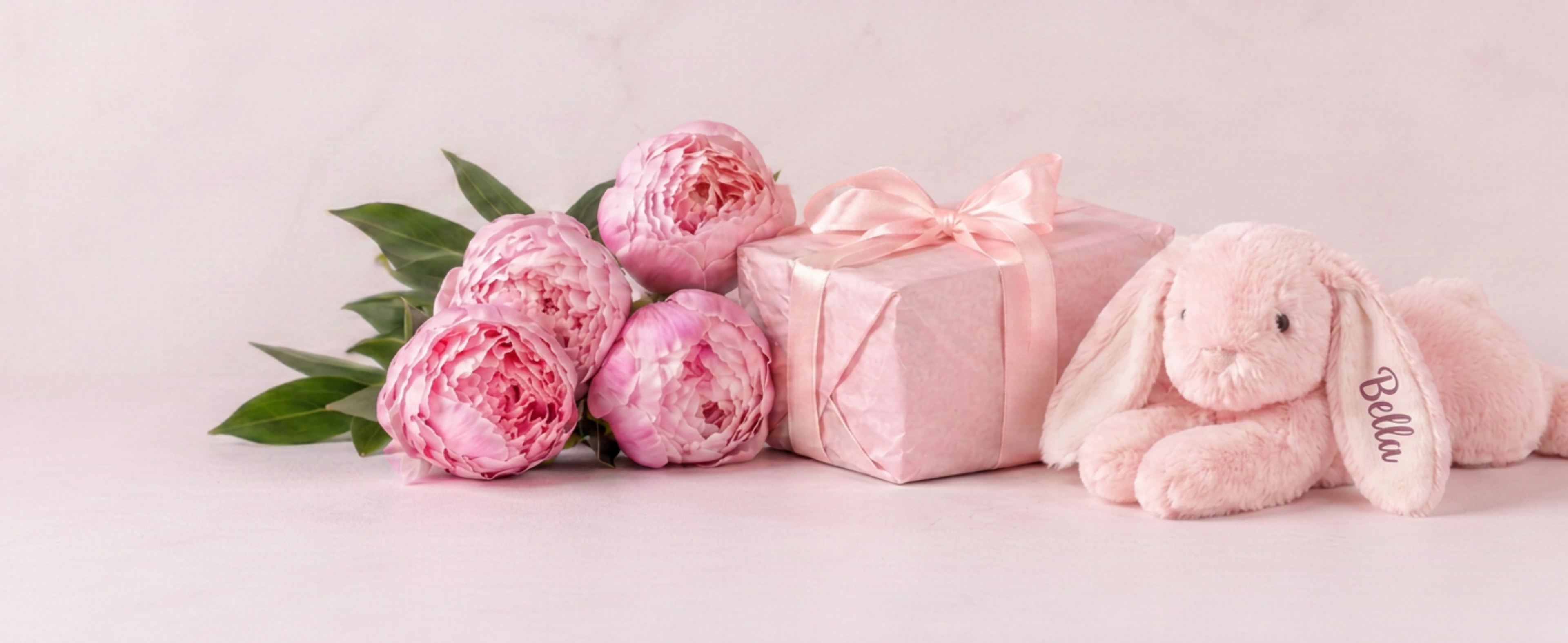 Personalised gift shop featuring gift wrapped dog toy, pink peonies and custom pet gifts