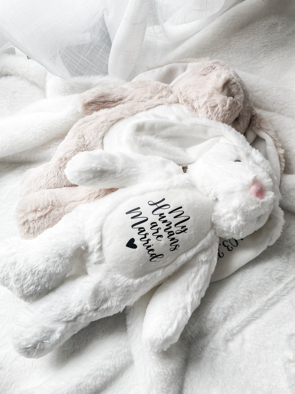 Personalised dog wedding gift bunny toys in white and light brown, styled in a home setting with the text detail 'my humans are married', personalised dog toy.