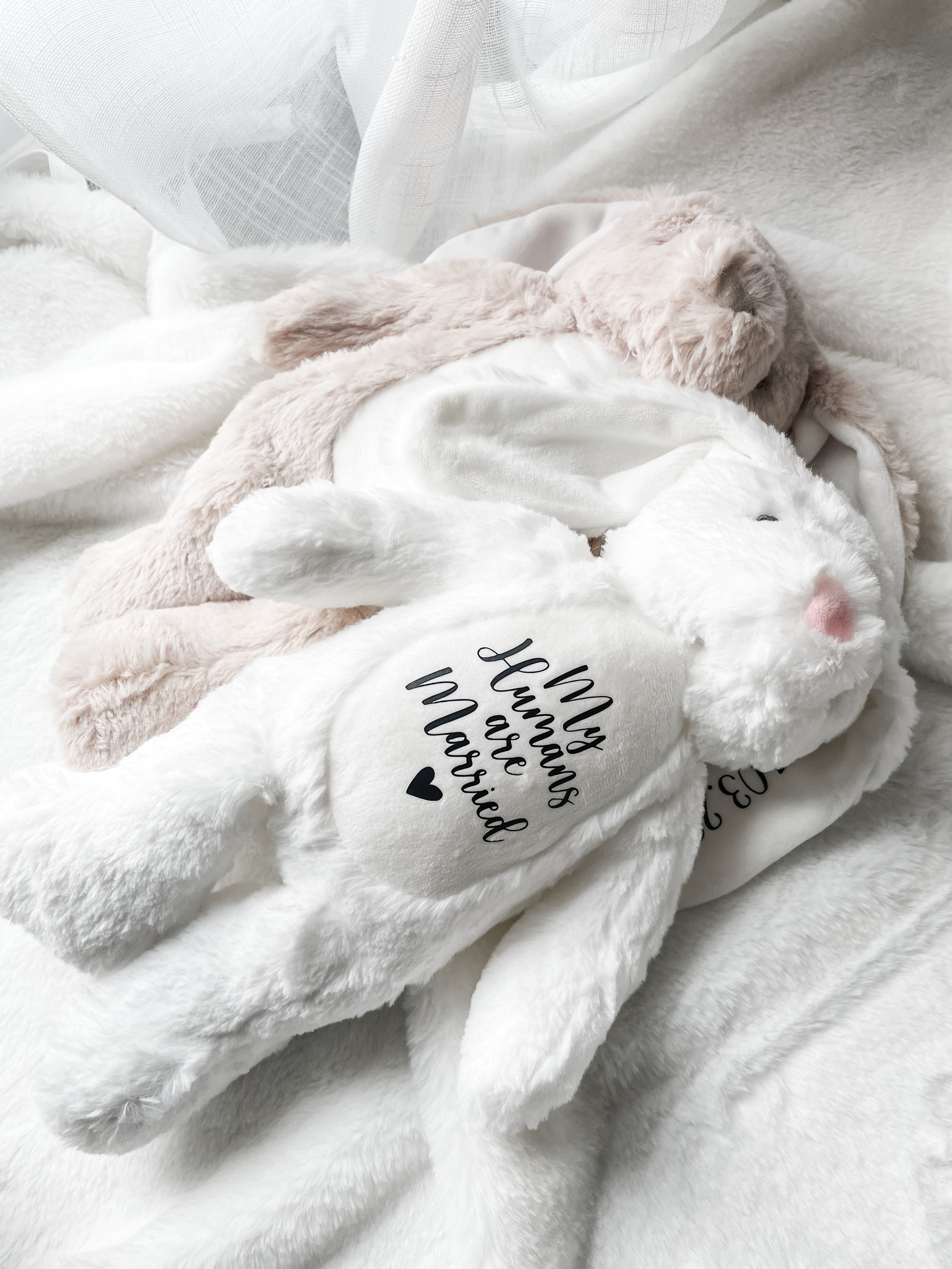 Personalised dog wedding gift bunny toys in white and light brown, styled in a home setting with the text detail 'my humans are married', personalised dog toy.