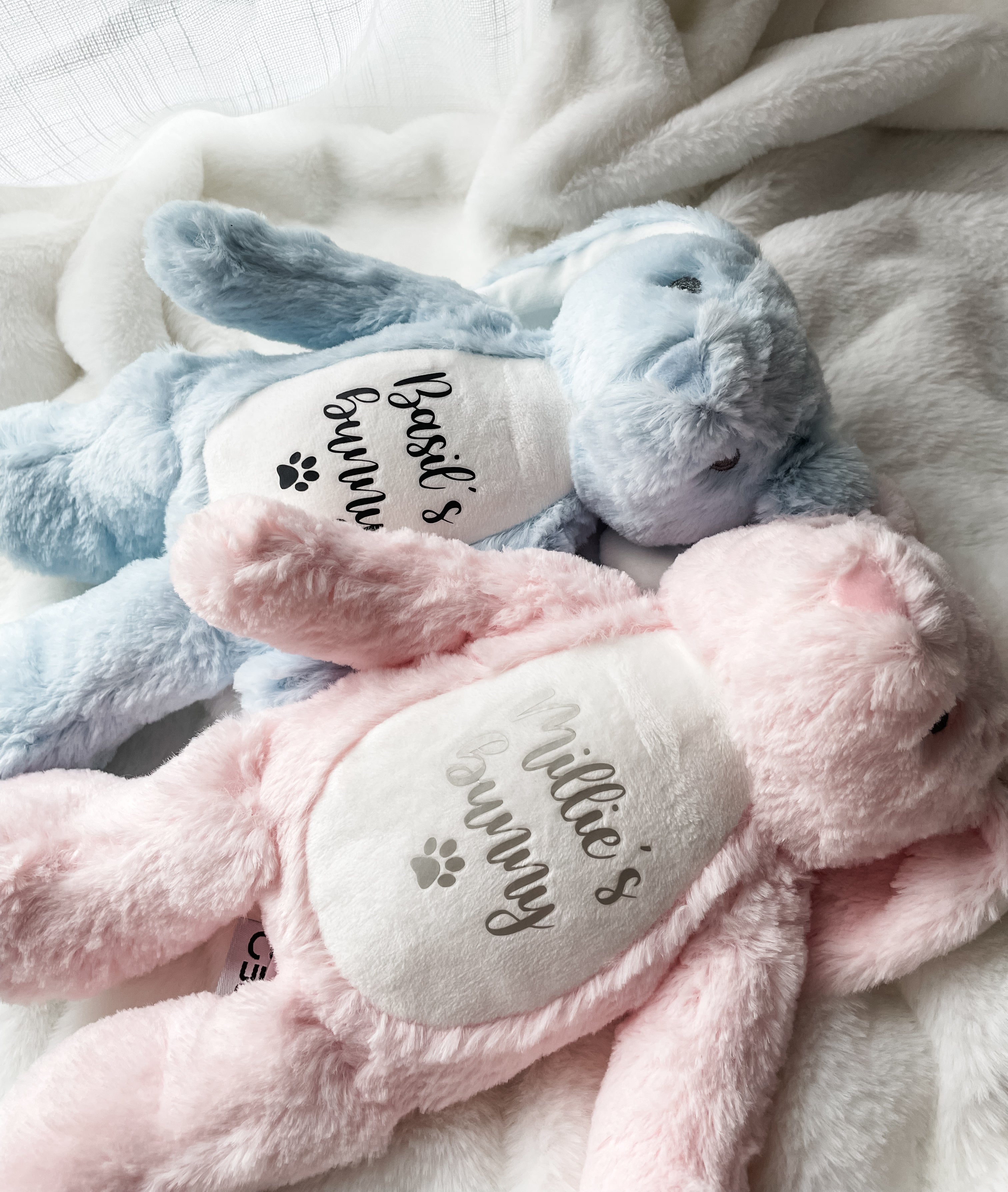 Pink and blue personalised bunny toys for dogs. Soft personalised Easter gifts featuring your dog's name and the word 'bunny' underneath with a paw print symbol. Custom dog Easter toy. 