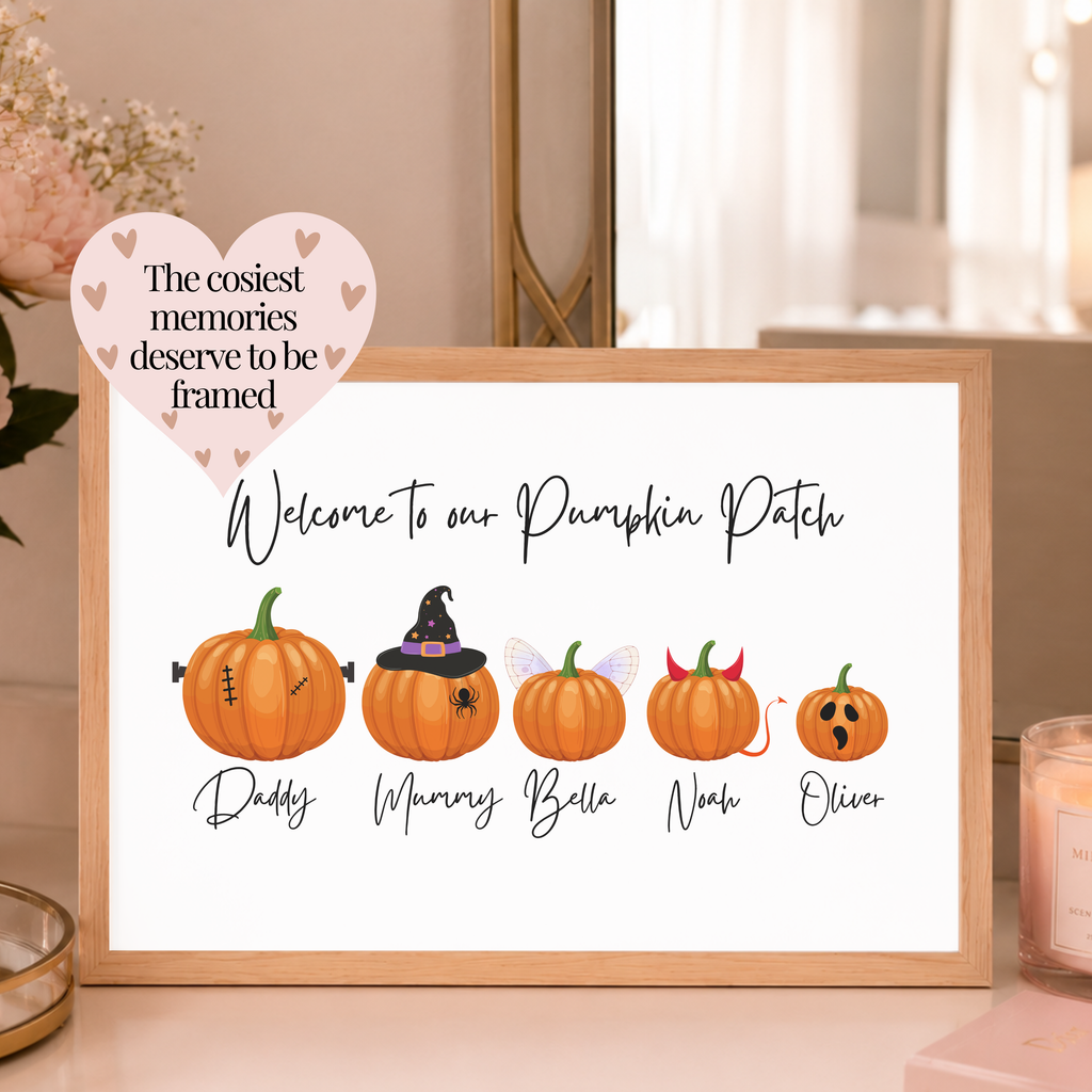 A framed personalised pumpkin patch print with cartoon pumpkins and names, displayed on a tabletop in a softly lit home setting. A pink heart-shaped overlay reads, 'The cosiest memories deserve to be framed. Personalised autumn decor for families.