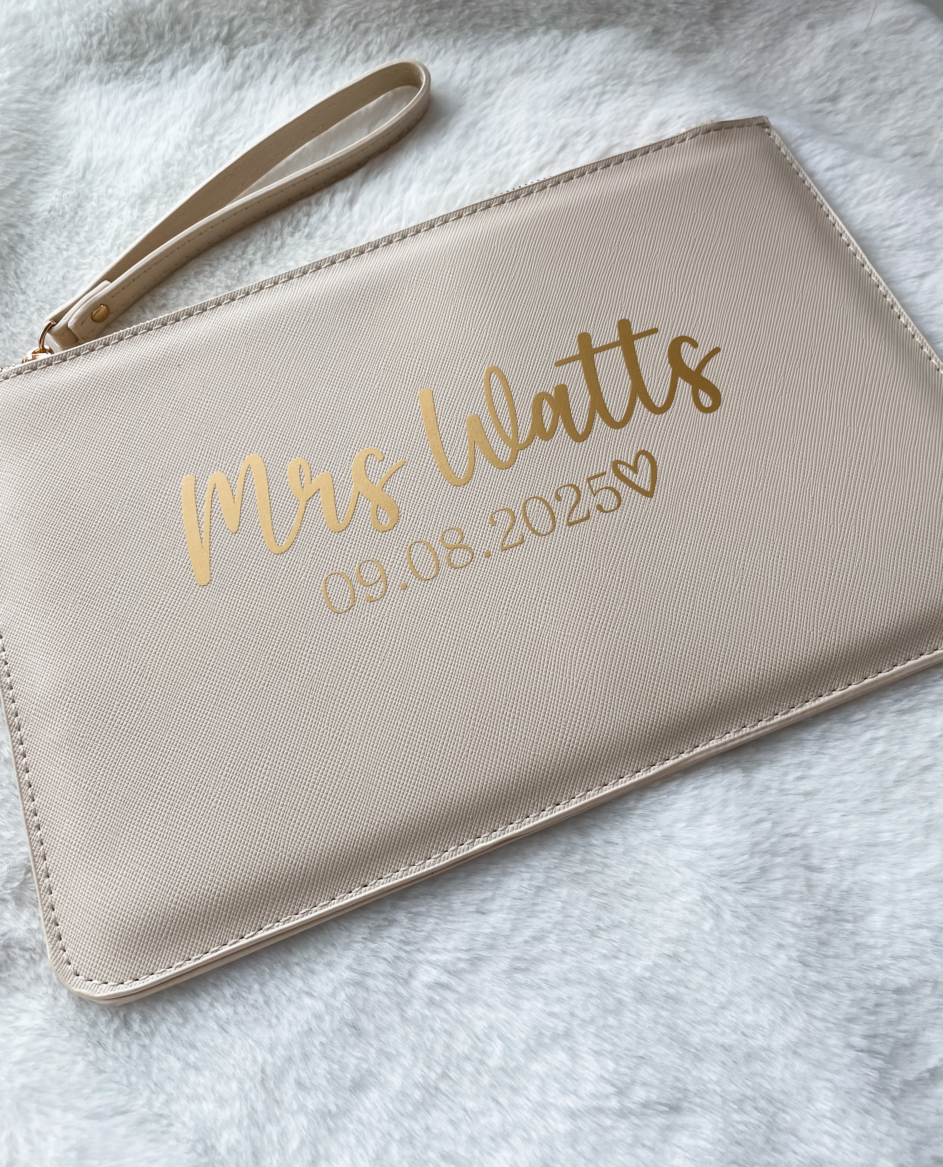 Personalised oyster/beige bridal clutch bag featuring the bride's new surname and wedding date. A thoughtful wedding day gift for the bride.