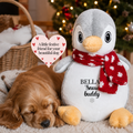 Personalised Christmas penguin dog toy beside a sleeping puppy in a cosy festive home. Personalised Christmas dog gift and stocking filler for dogs.