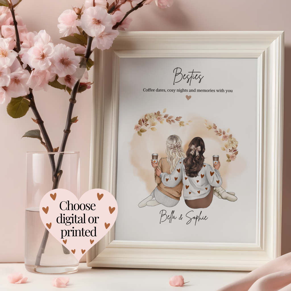 A framed personalised autumn print displayed on a tabletop next to a glass vase with pink blossoms. The print features an illustration of two besties holding pumpkin spiced lattes wearing cosy jumpers, leggings and brown gingham hair bows. Personalised cosy gift for her.