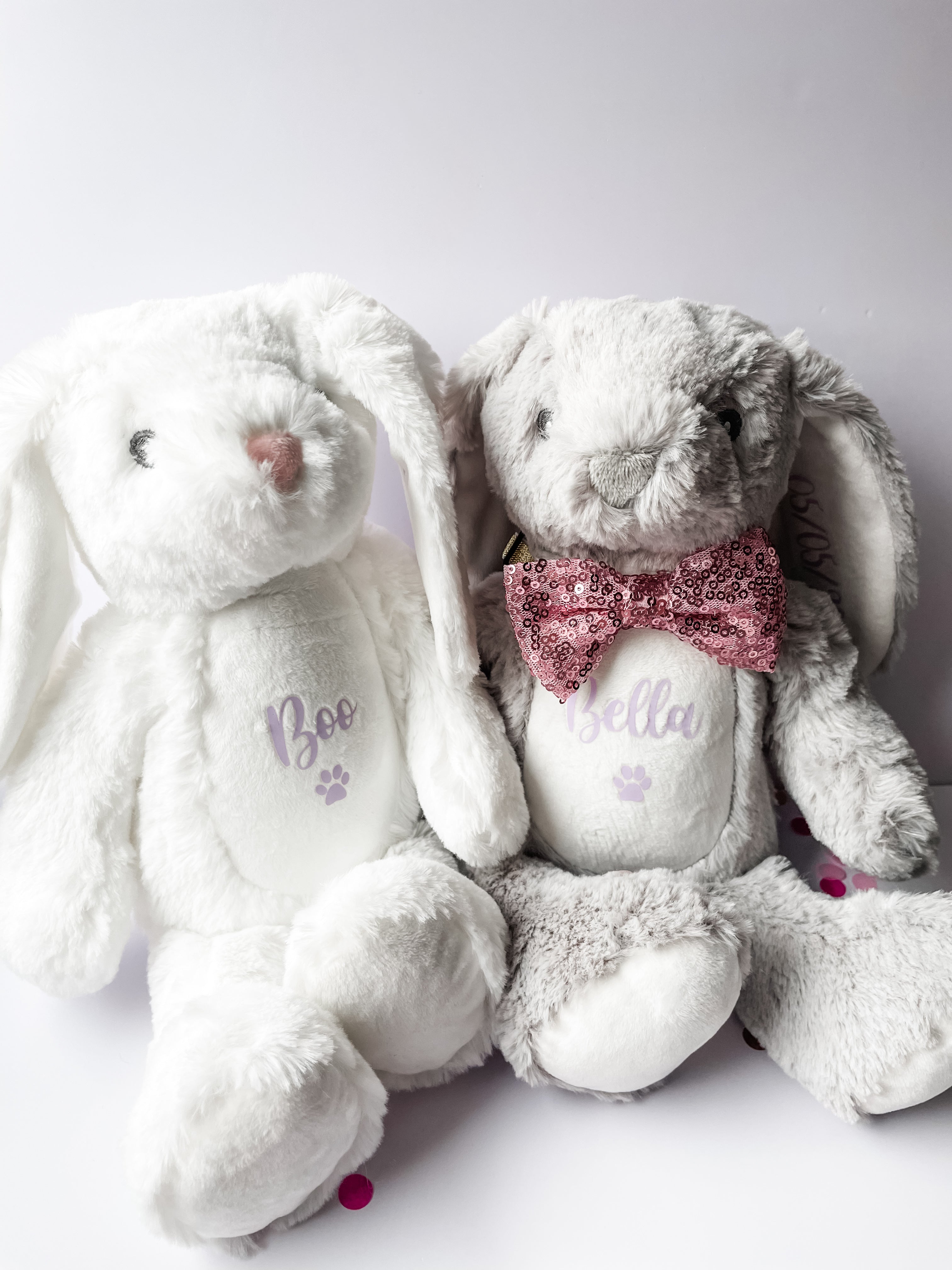 White and grey personalised birthday bunny toys displayed in a cosy home. Custom dog birthday gift.