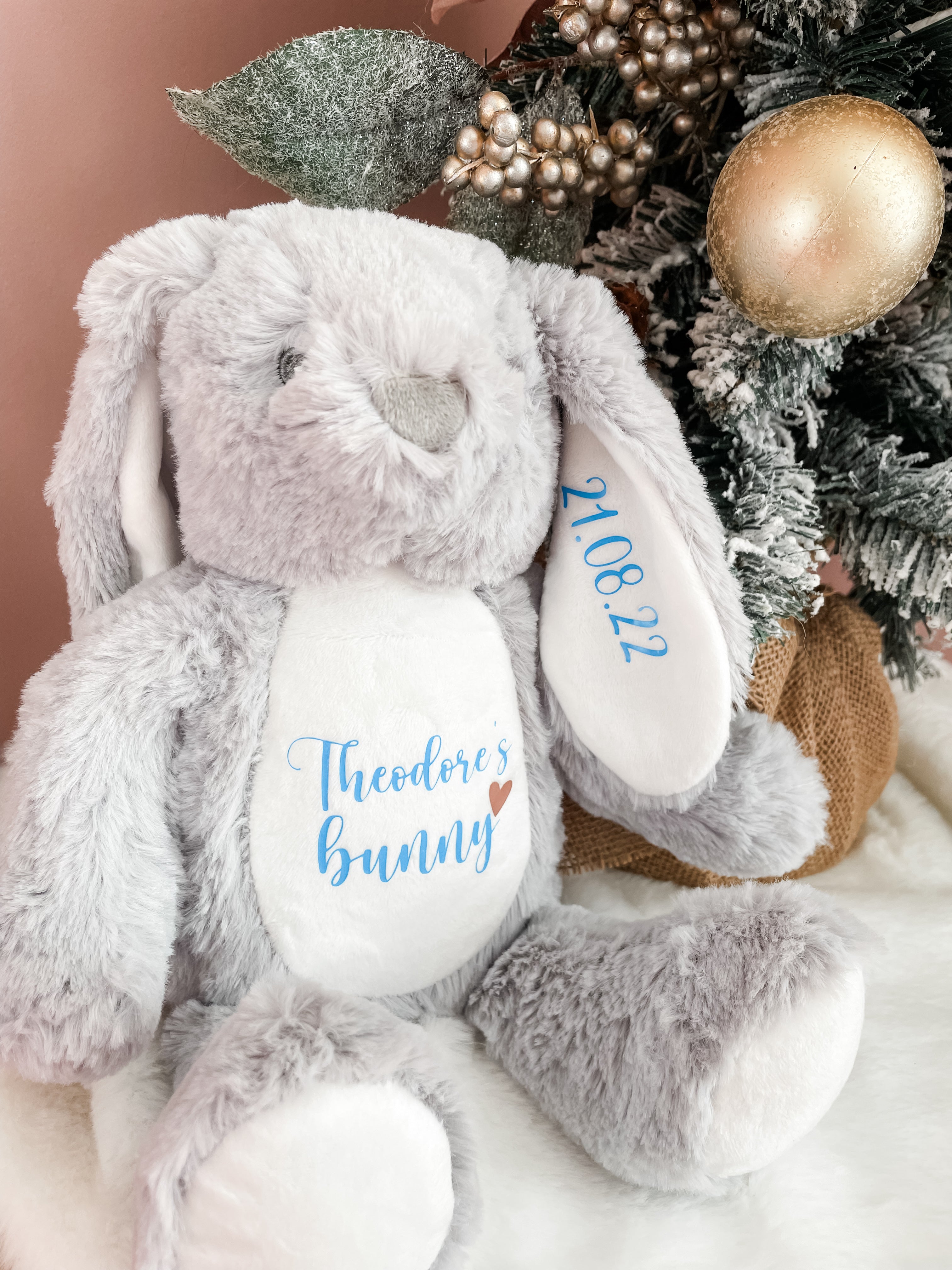 Personalised bunny dog toy beside a Christmas tree. Festive personalised dog gift with custom name. Dog stocking filler. 