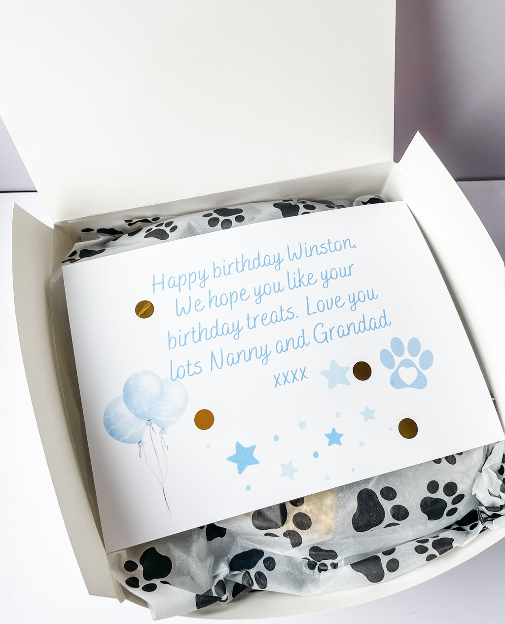 Open personalised dog birthday hamper with custom gift message card inside, personalised dog toy and treat bag. Custom dog accessories.