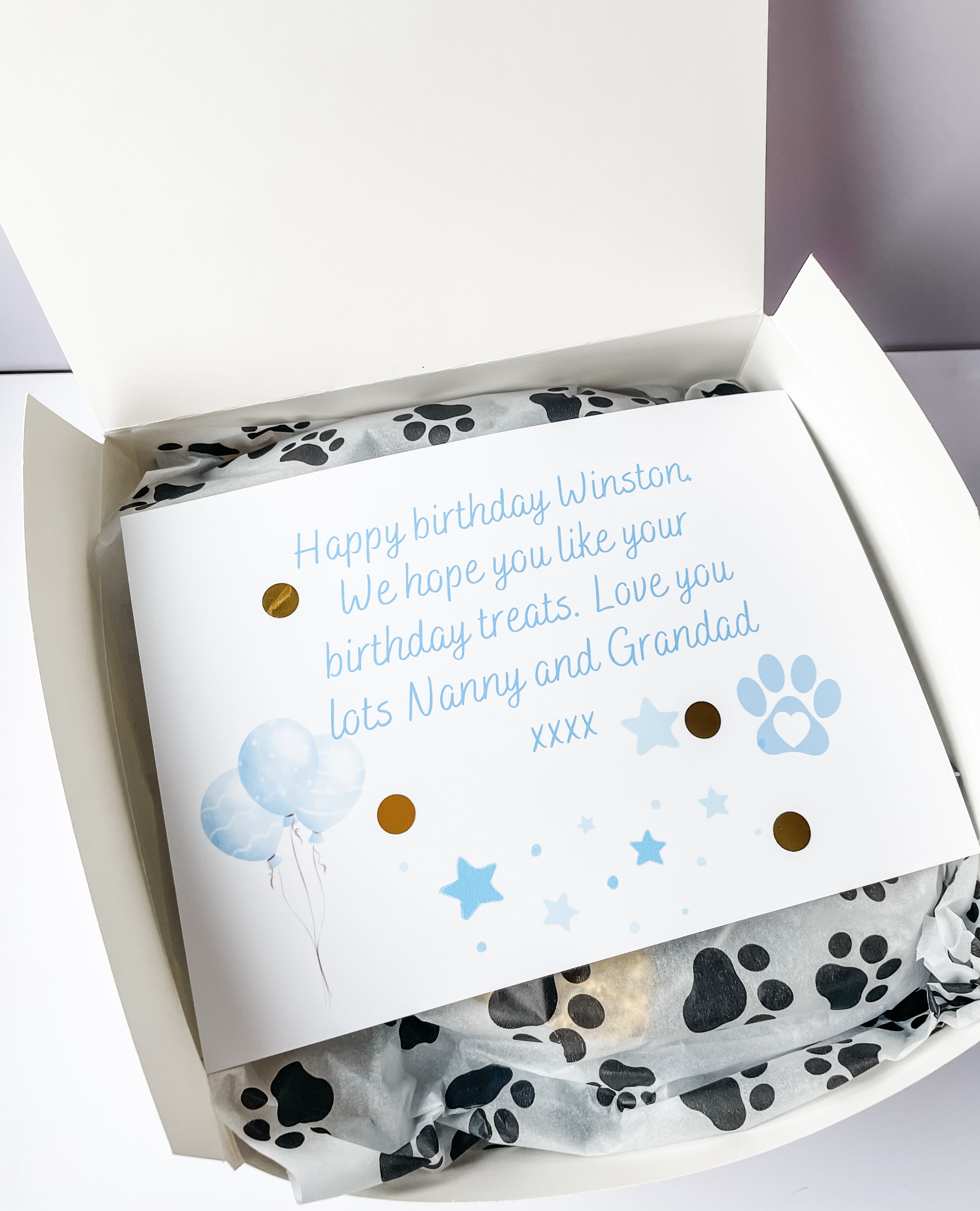 Open personalised dog birthday hamper with custom gift message card inside, personalised dog toy and treat bag. Custom dog accessories.