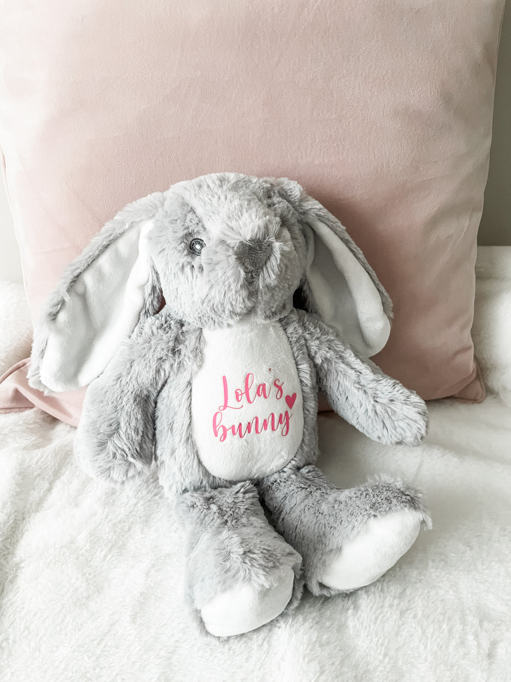 Personalised grey bunny dog toy displayed in a cosy home setting. Custom dog toy with personalised name.