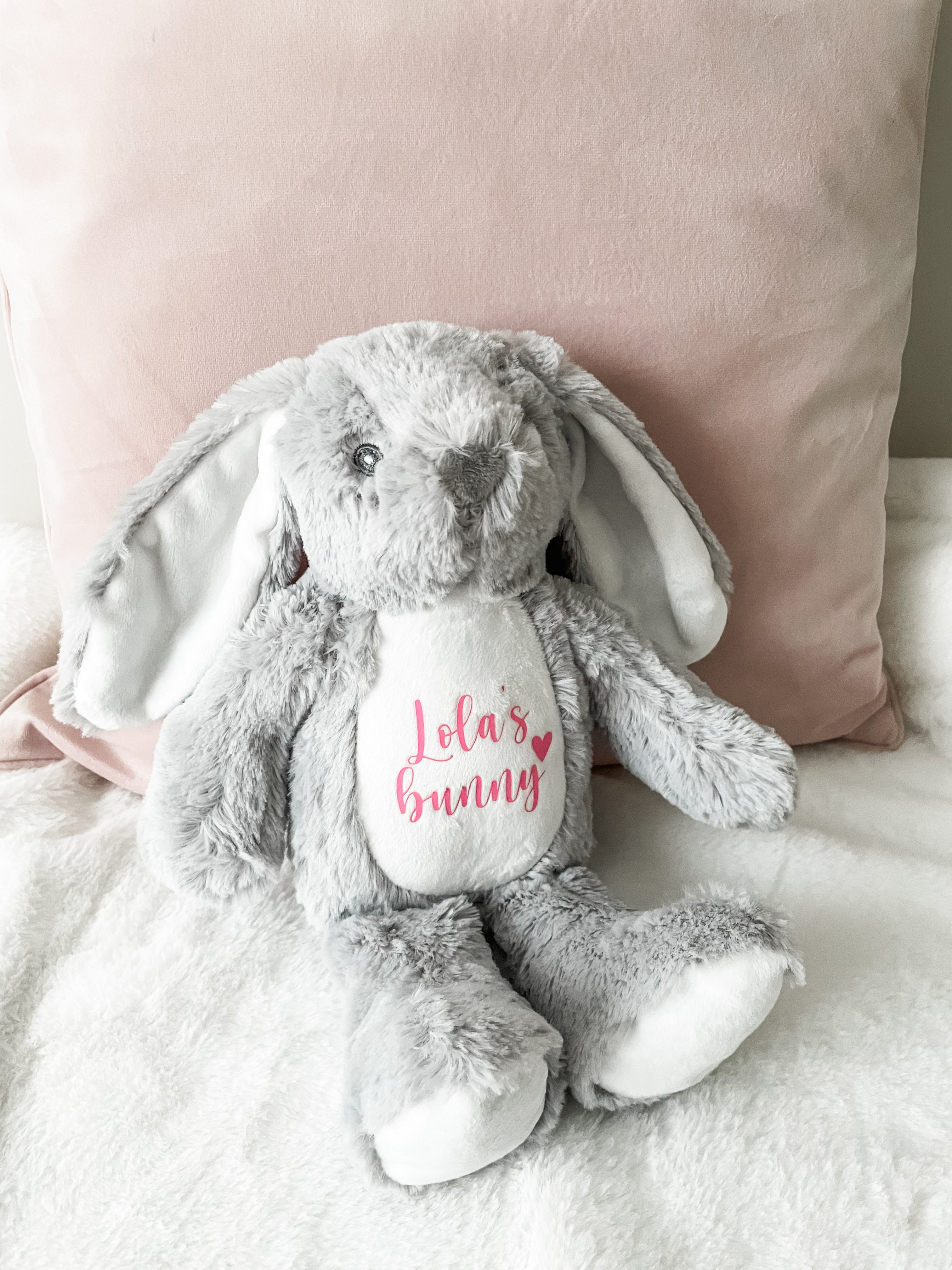Personalised grey bunny dog toy displayed in a cosy home setting. Custom dog toy with personalised name.