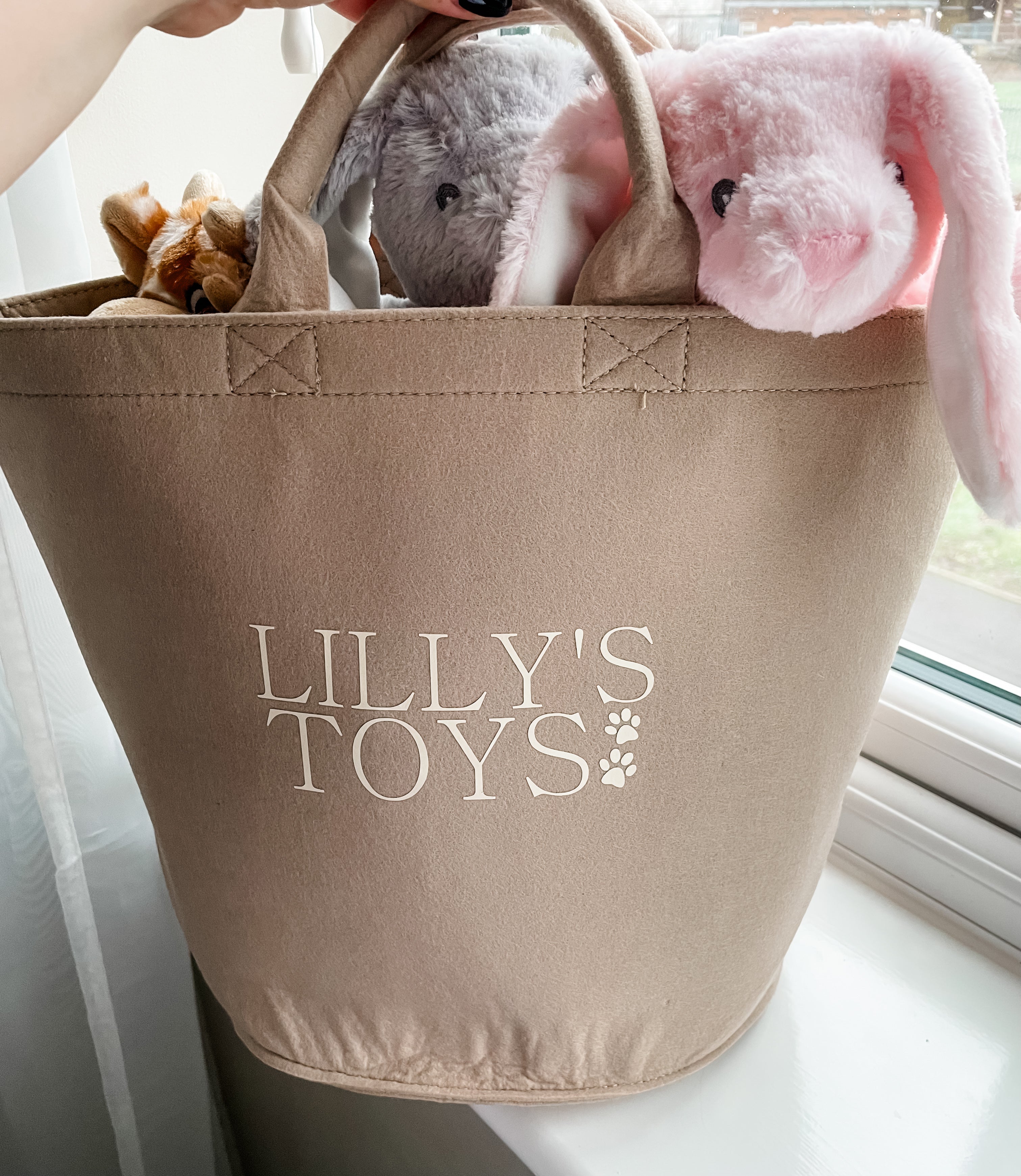 Soft plush beige dog toy basket with custom dog name, neatly storing favourite dog toys.