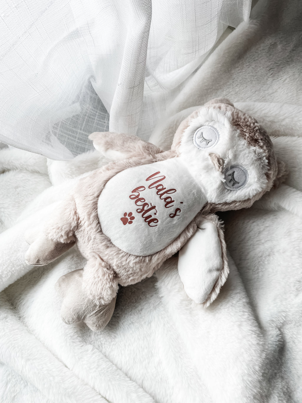 Personalised cat plush owl toy styled in a home setting with the cat's name personalised, the word 'bestie' underneath and a small paw print symbol. Personalisation new kitten gift.