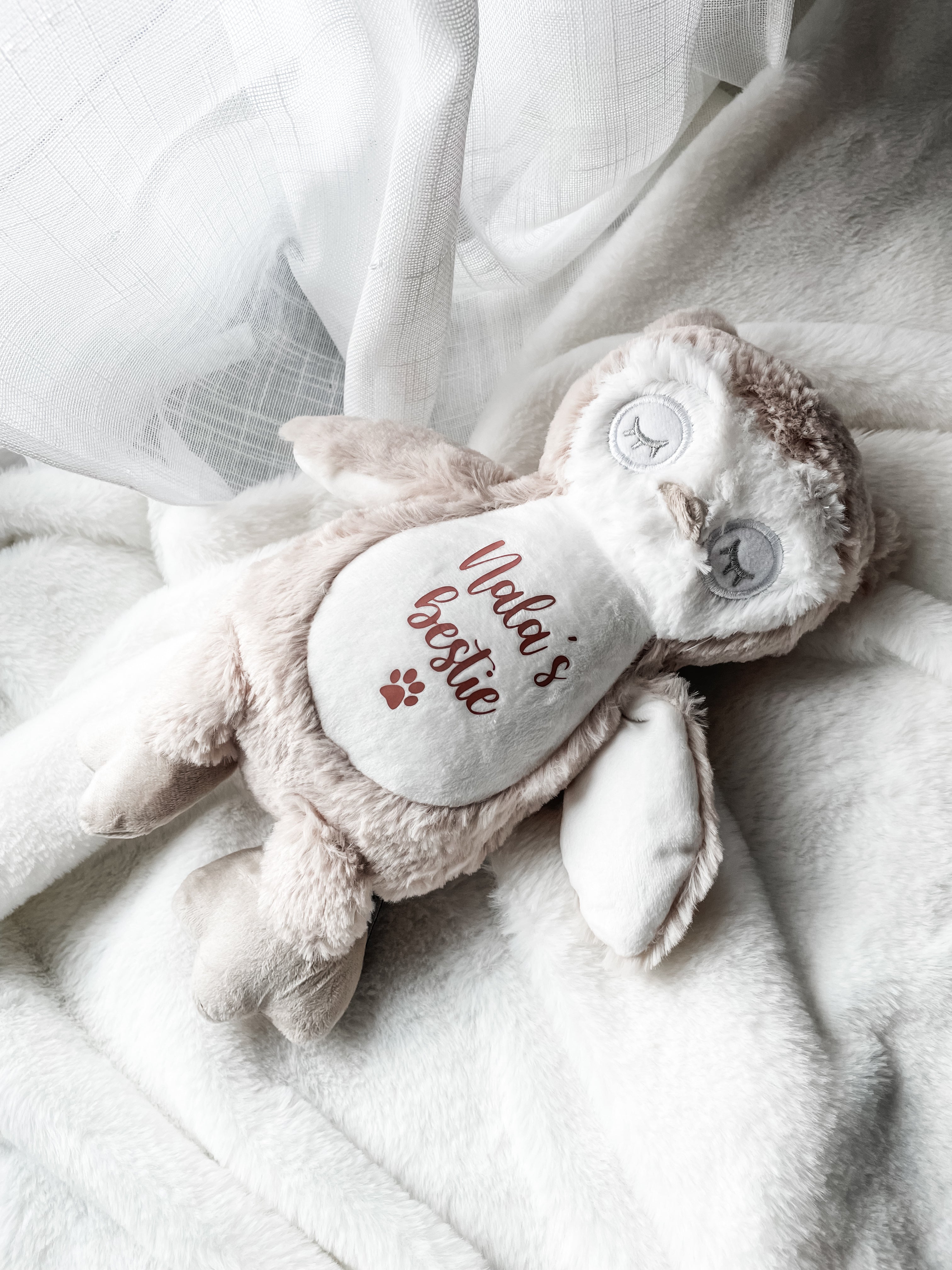 Personalised cat plush owl toy styled in a home setting with the cat's name personalised, the word 'bestie' underneath and a small paw print symbol. Personalisation new kitten gift.