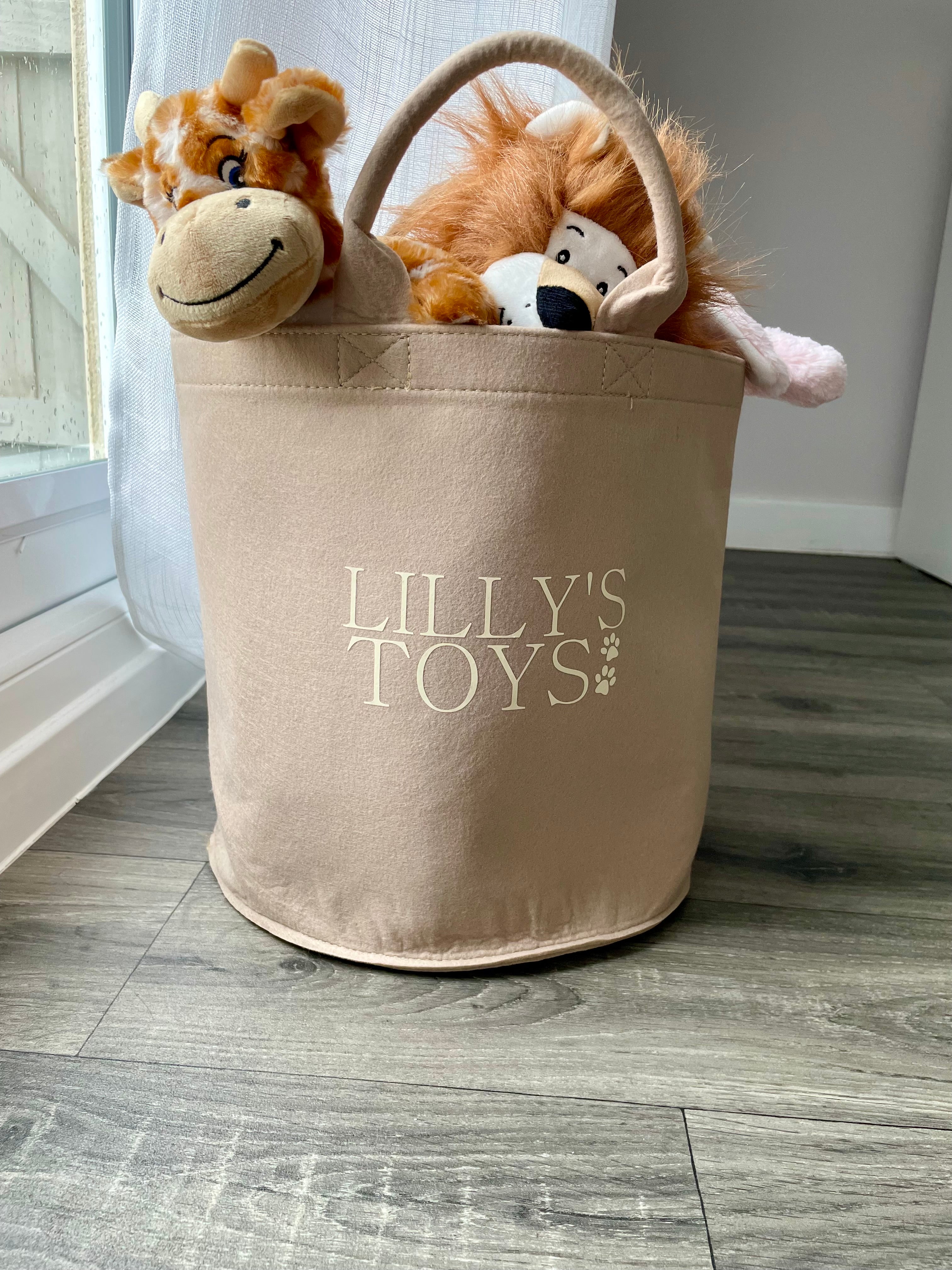 Neutral personalised dog toy basket styled in a cosy living room with soft home decor, filled with custom dog plush toys.