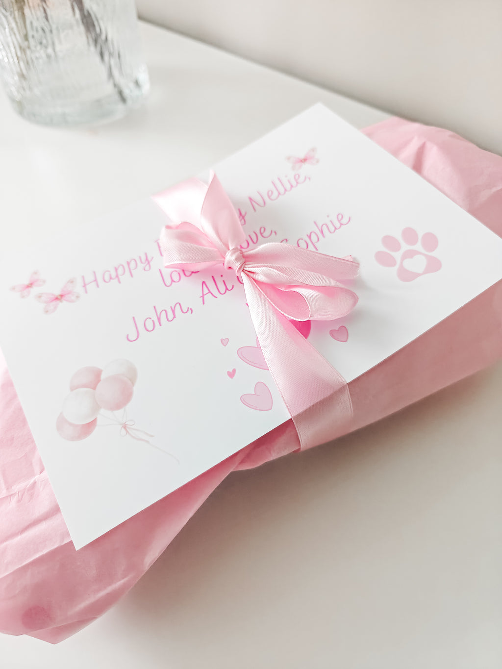 Pink gift wrapped personalised dog toy with satin bow and gift message card for a dog birthday.