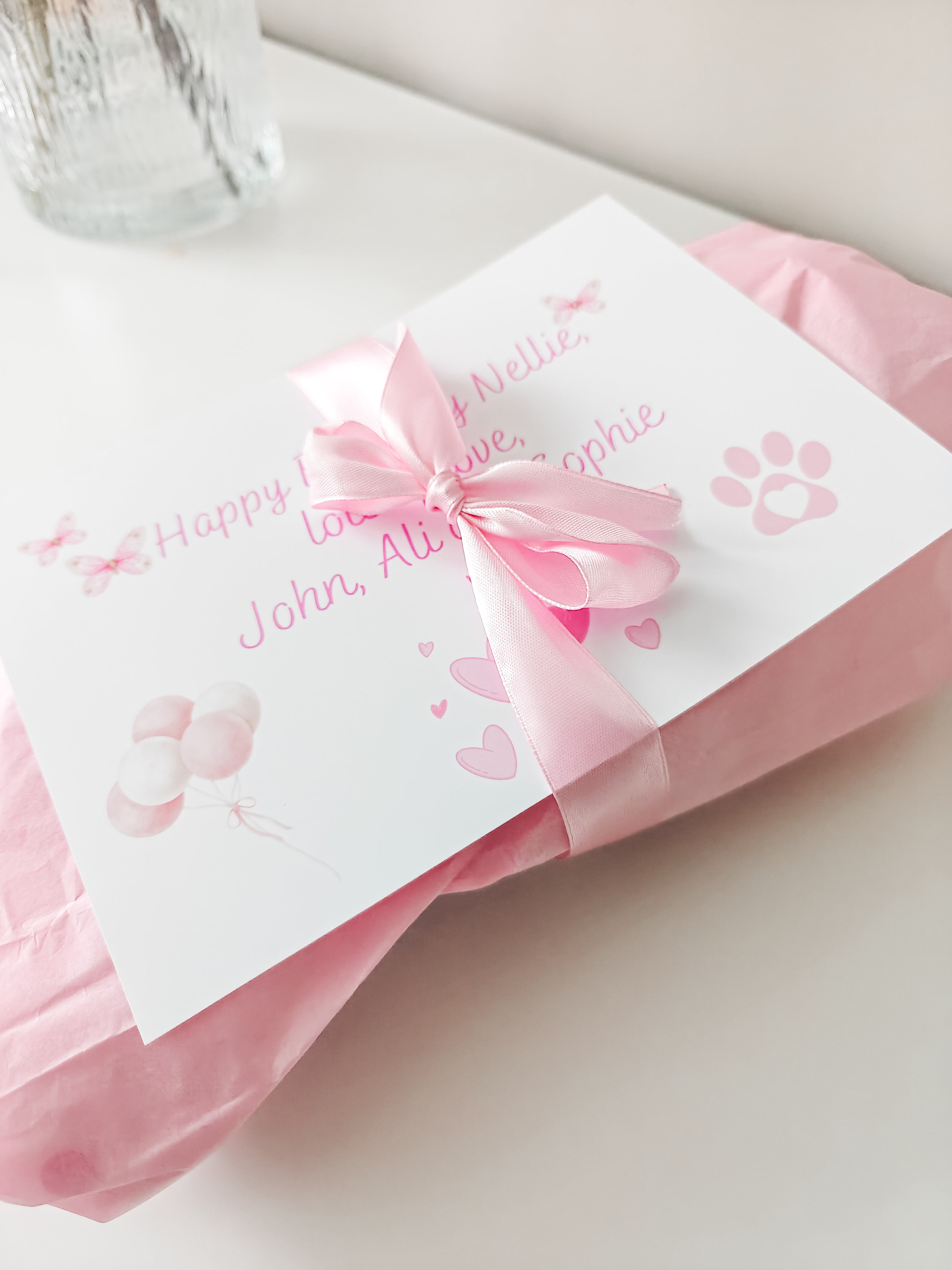 Pink gift wrapped personalised dog toy with satin bow and gift message card for a dog birthday.