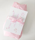 Pink luxury gift wrapped dog toy with tissue paper, satin ribbon bow and personalise gift message card.