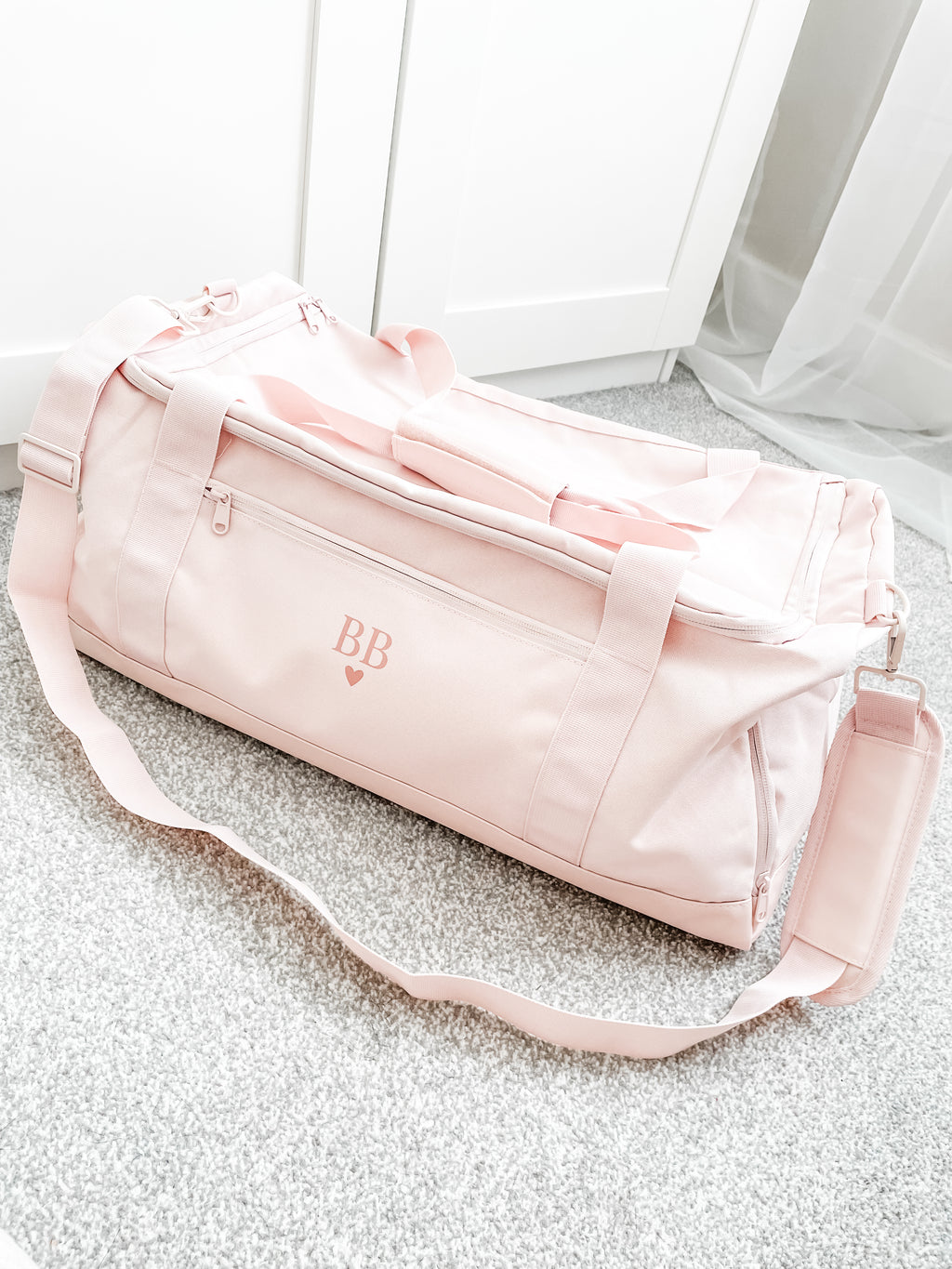 Personalised initial duffle bag in soft pink, custom gym bag for women with detachable shoulder strap and spacious design. Custom gym training bag for her.