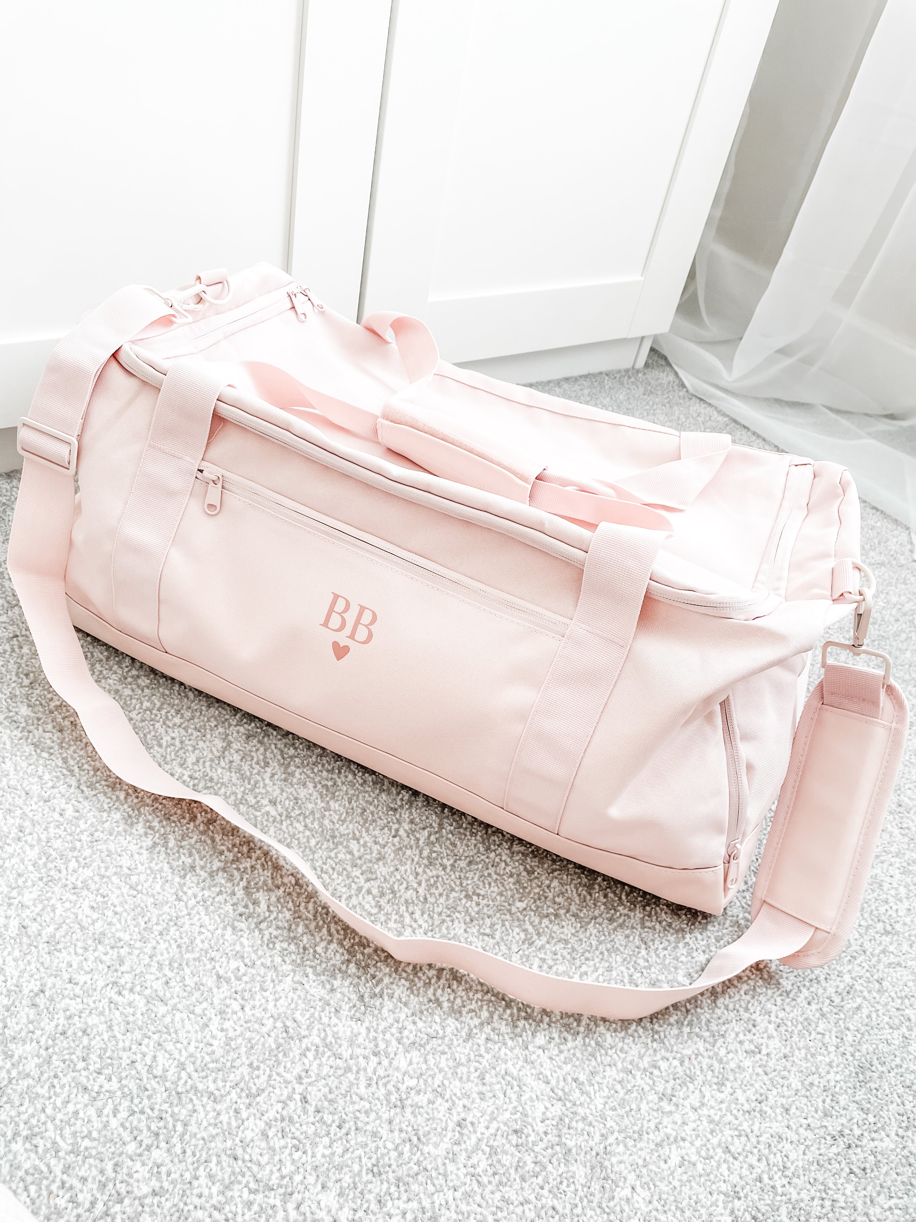Personalised initial duffle bag in soft pink, custom gym bag for women with detachable shoulder strap and spacious design. Custom gym training bag for her.