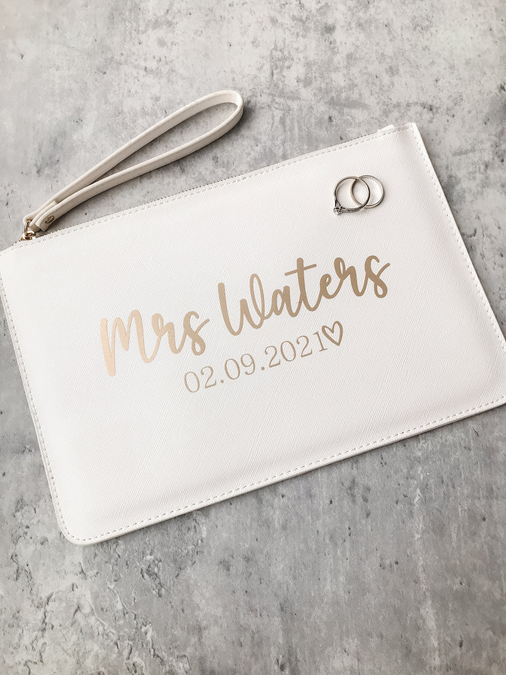Video showing a personalised bride clutch bag with custom wedding surname and date. Elegant wedding day keepsake.