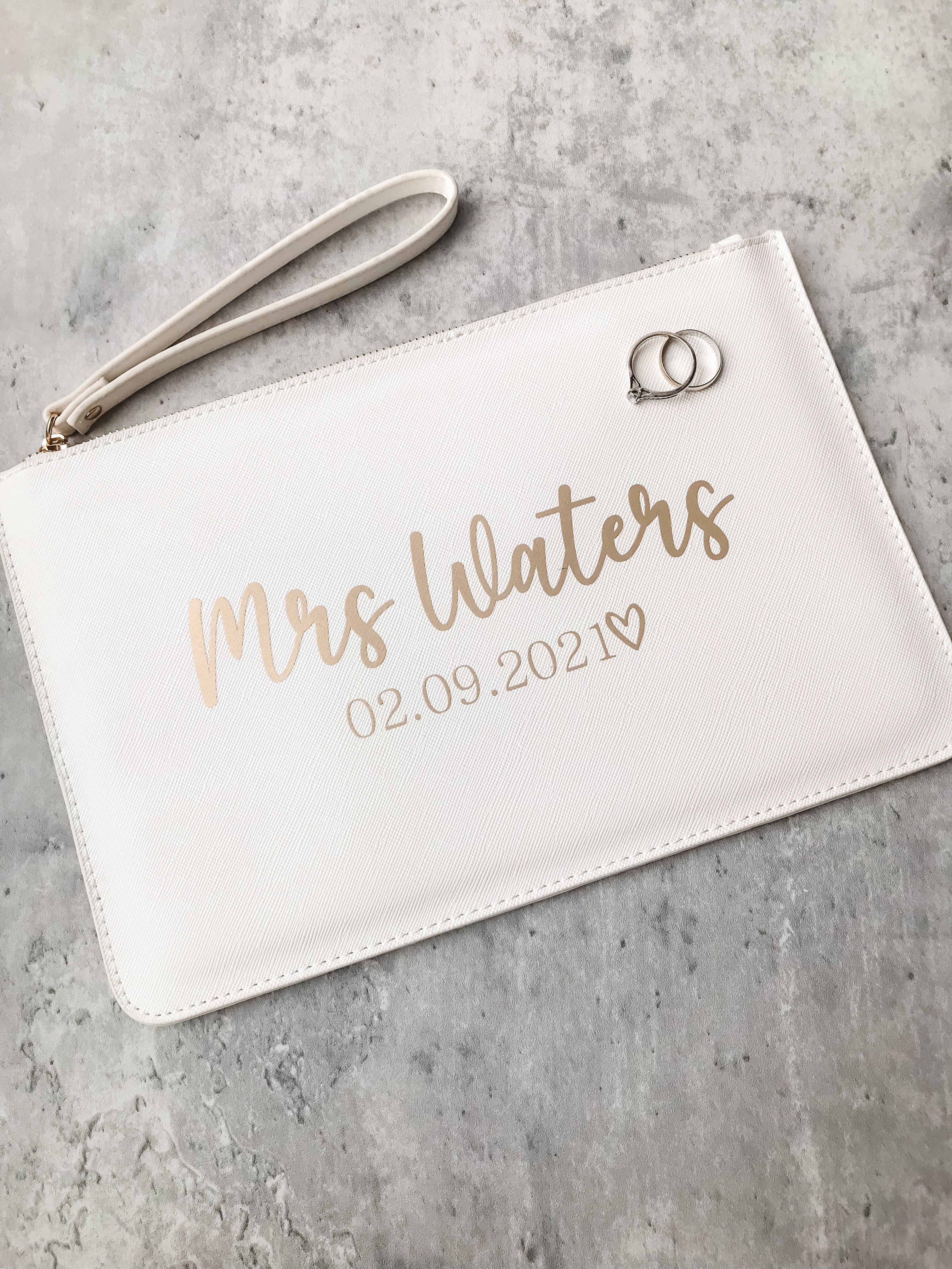 Video showing a personalised bride clutch bag with custom wedding surname and date. Elegant wedding day keepsake.