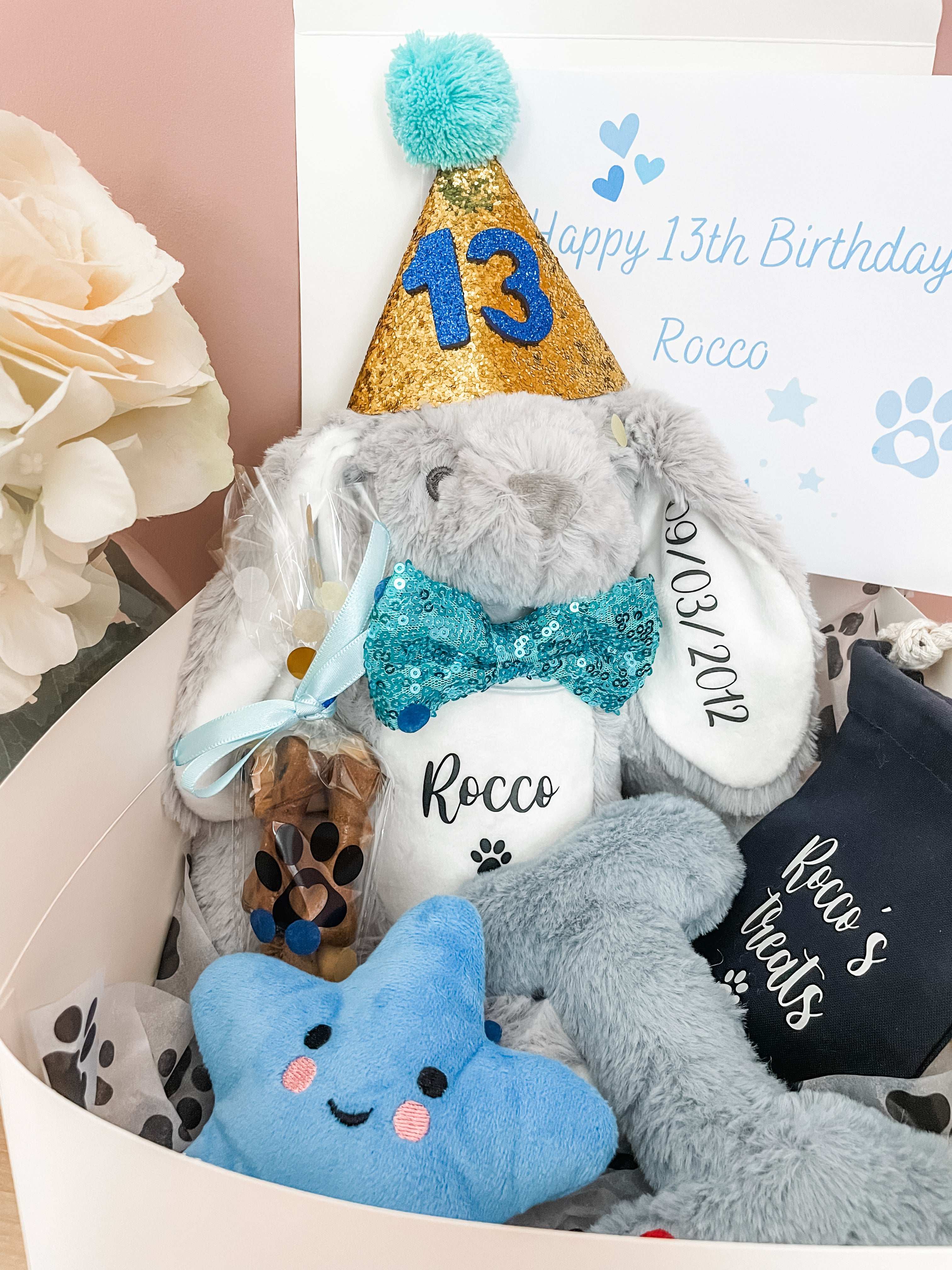 Video showing luxury personalised dog birthday hamper with bunny toy, plush toys, birthday treats and gift wrapping.