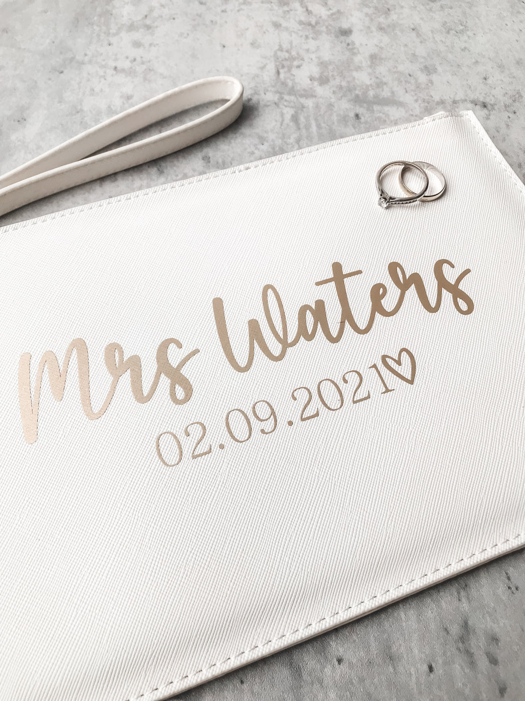Personalised bride clutch bag featuring custom surname and wedding date. A beautiful wedding morning gift for the bride-to-be.